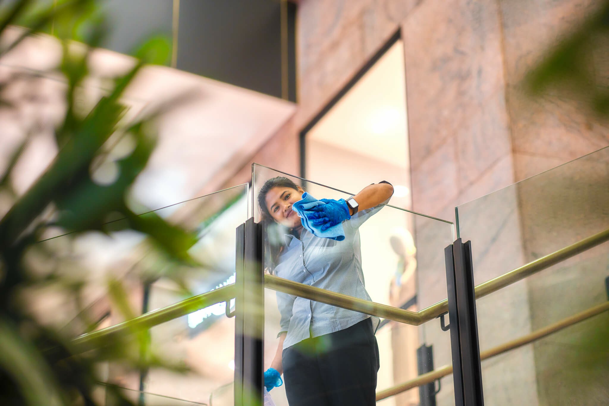 Worker cleaning workplace glass balustrade